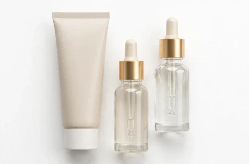Skincare cream tube and serum bottles on a clean white background