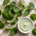 Fresh centella asiatica leaves and green cream dish flat lay