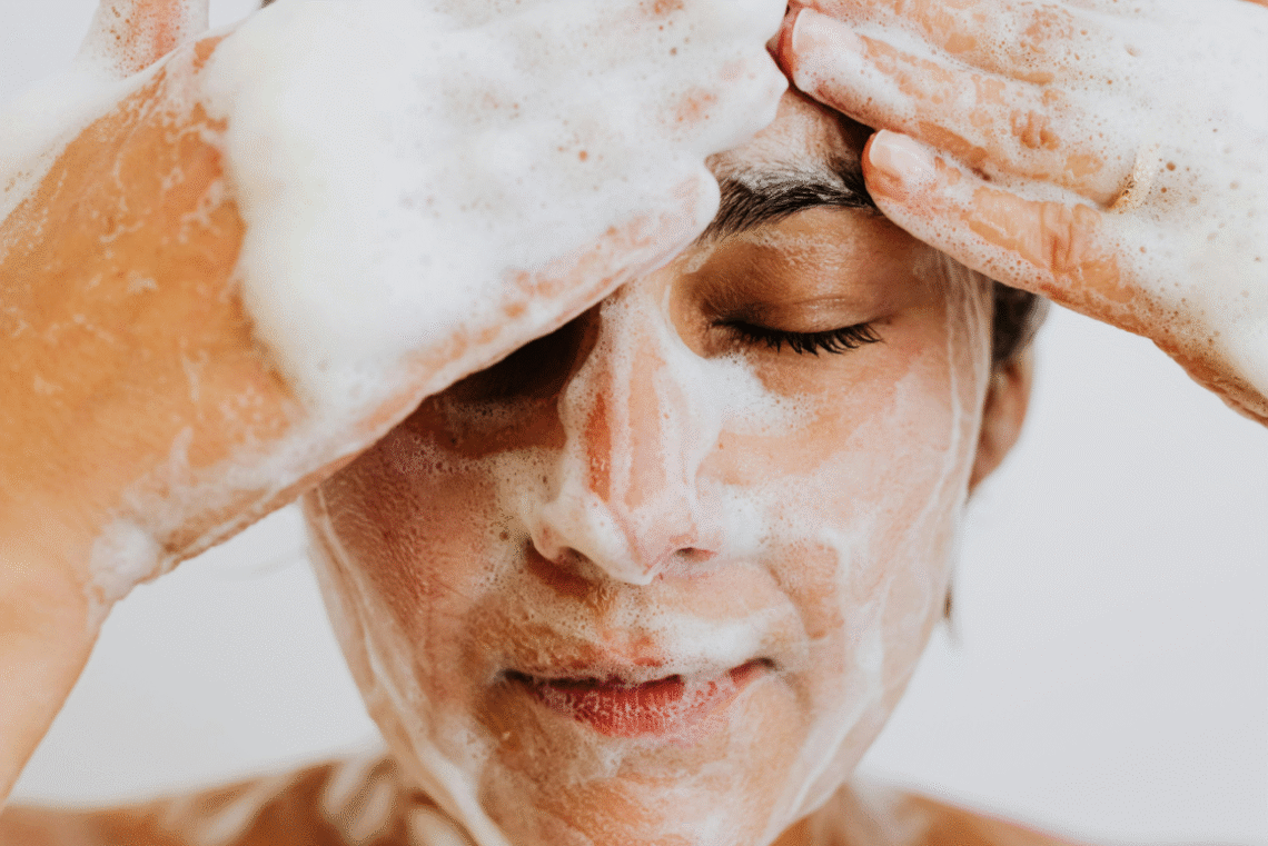 Person washing their face with a gentle foaming cleanser for oily skin