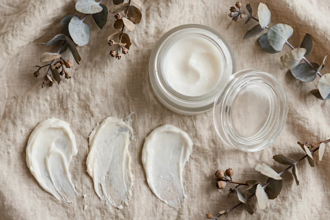 Moisturizer jar and cream swatches on a neutral background