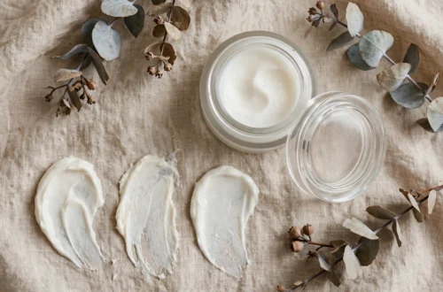 Moisturizer jar and cream swatches on a neutral background