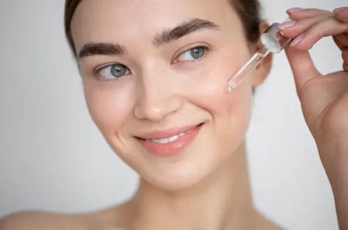 A woman gently applying facial serum with a dropper