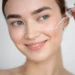 A woman gently applying facial serum with a dropper