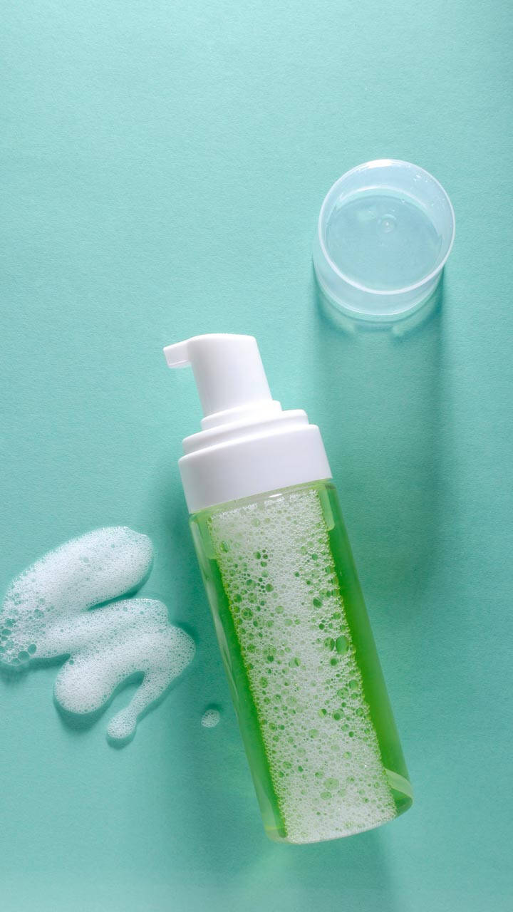 Woman rinsing her face while following an oily skin care routine