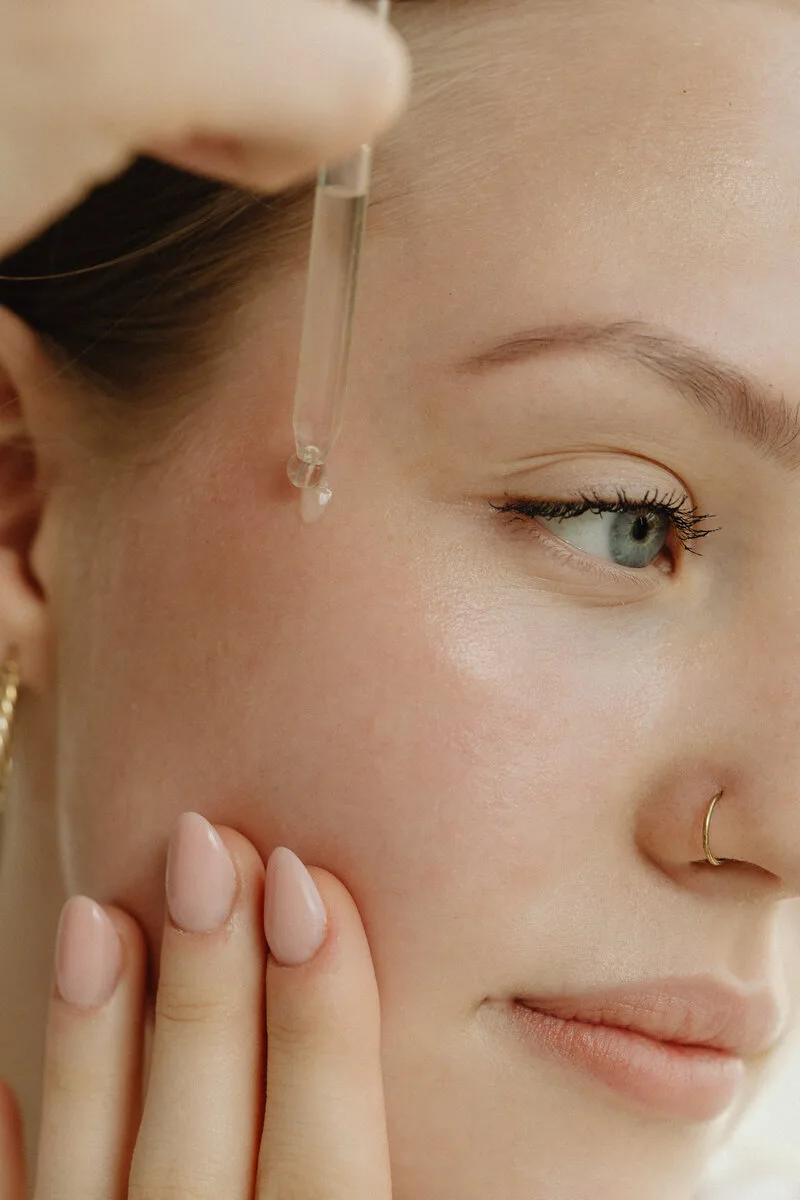 Person applying facial serum as part of a skincare routine