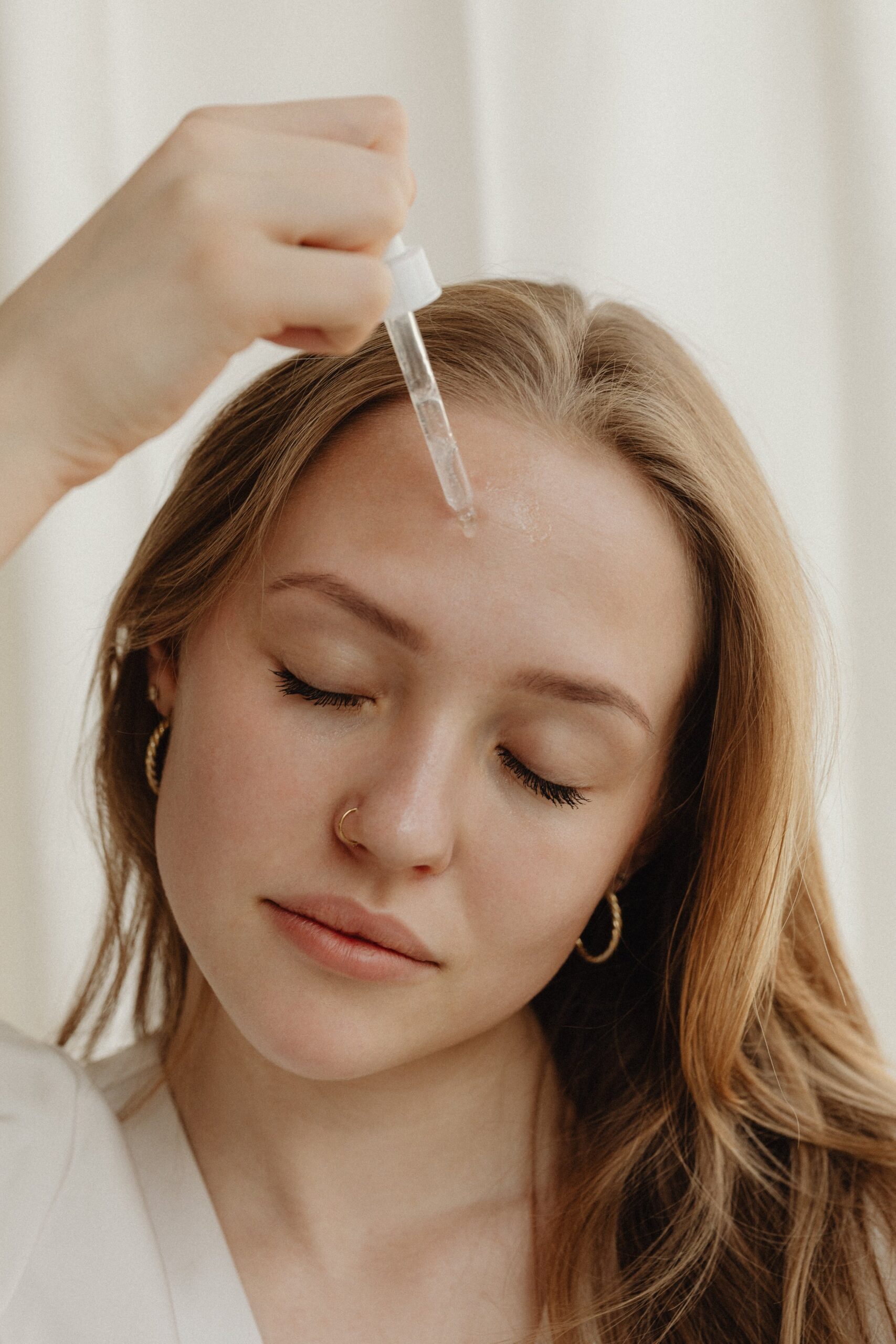Close-up of applying skincare serum to the face